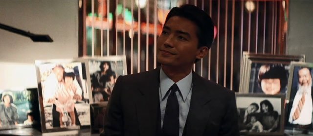 《龙年》中尊龙饰演的黑帮头子,身后的照片展示了他温情一面 《龙年》中尊龙饰演的黑帮头子,身后的照片展示了他温情一面